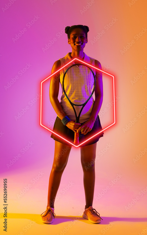 非裔美国微笑网球运动员在渐变背景下用发光的六边形握球拍