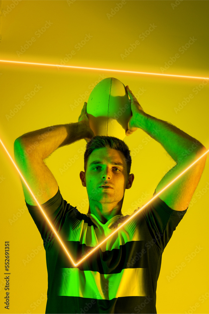 高加索男子橄榄球运动员在黄色背景上用发光三角形投球的肖像