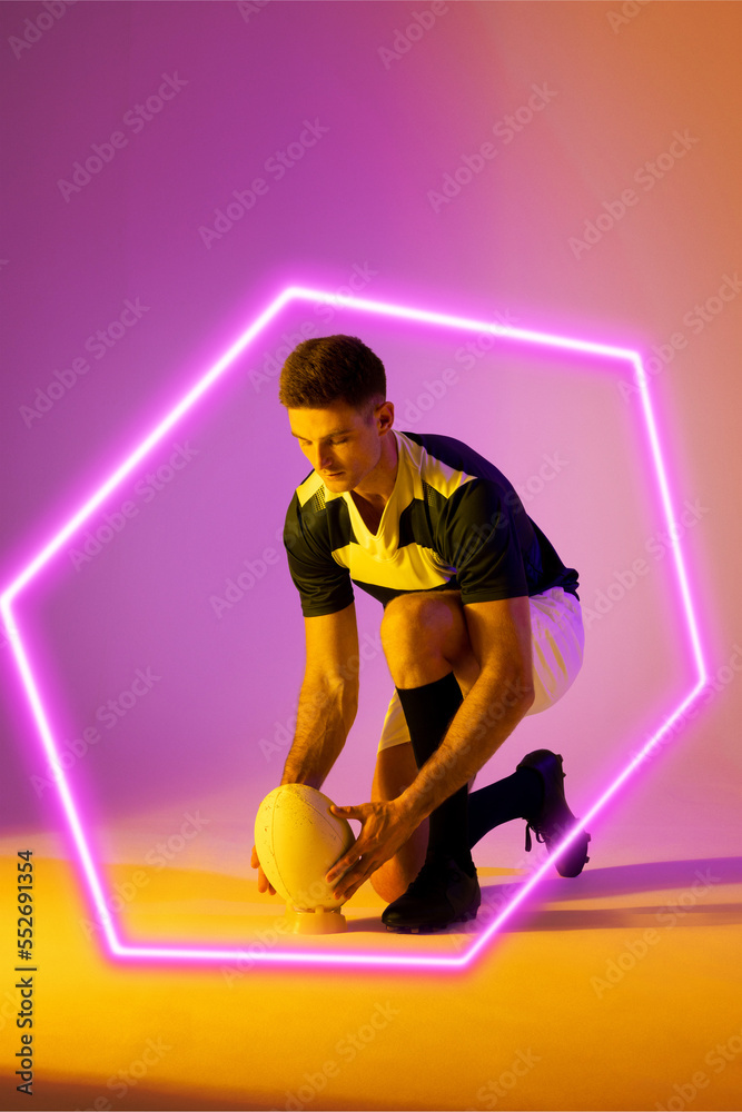 高加索男子橄榄球运动员将球放在渐变背景上的照明六边形上