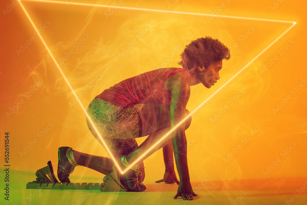 非裔美国女运动员在起跑位置的侧视图，三角形照明