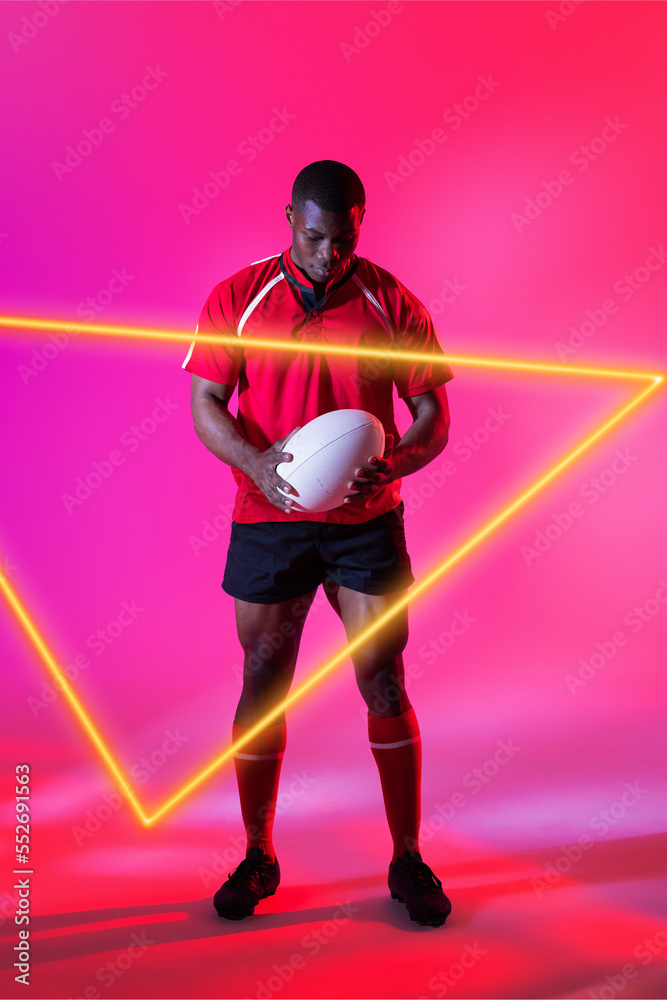 自信的非裔美国男子橄榄球运动员，粉色背景的发光三角形拿球