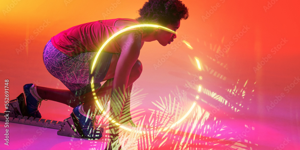 蹲在起跑位置的非裔美国女运动员头顶上的发光圆圈和植物