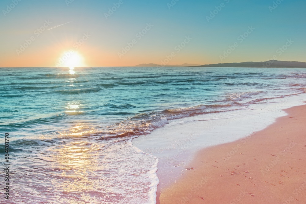 从粉红色的海滩上看五彩缤纷的日落，海浪柔和