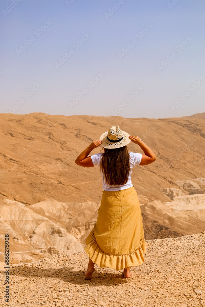Young woman in desert, back view