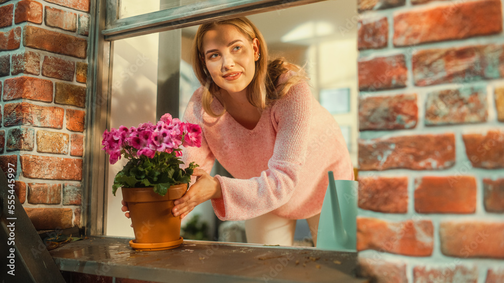 一位年轻女性在时尚公寓窗台上浇花的特写肖像。