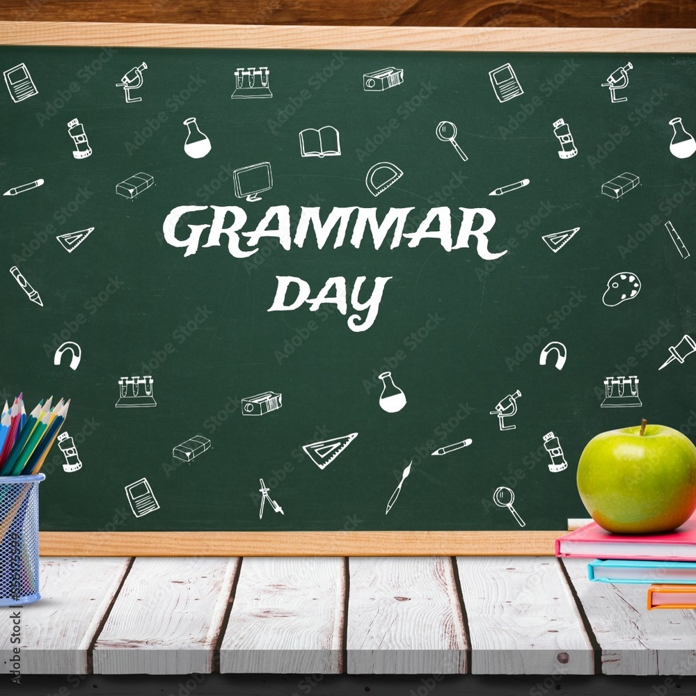 Apple on stack of books and pencil stand on wooden table against grammar day text on blackboard