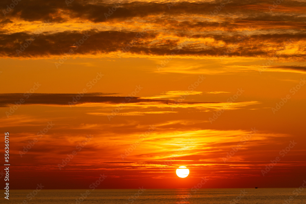 Beautiful light nature red sun in the golden sky and dark clouds seascape,Landscape nature backgroun