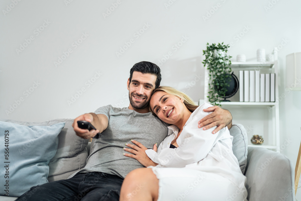 高加索年轻情侣在家里的客厅里一起看电影。