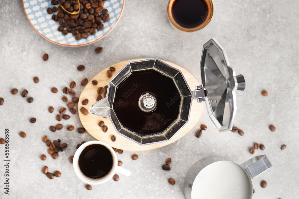 间歇泉咖啡机，一杯浓咖啡，灰色背景的牛奶和咖啡豆