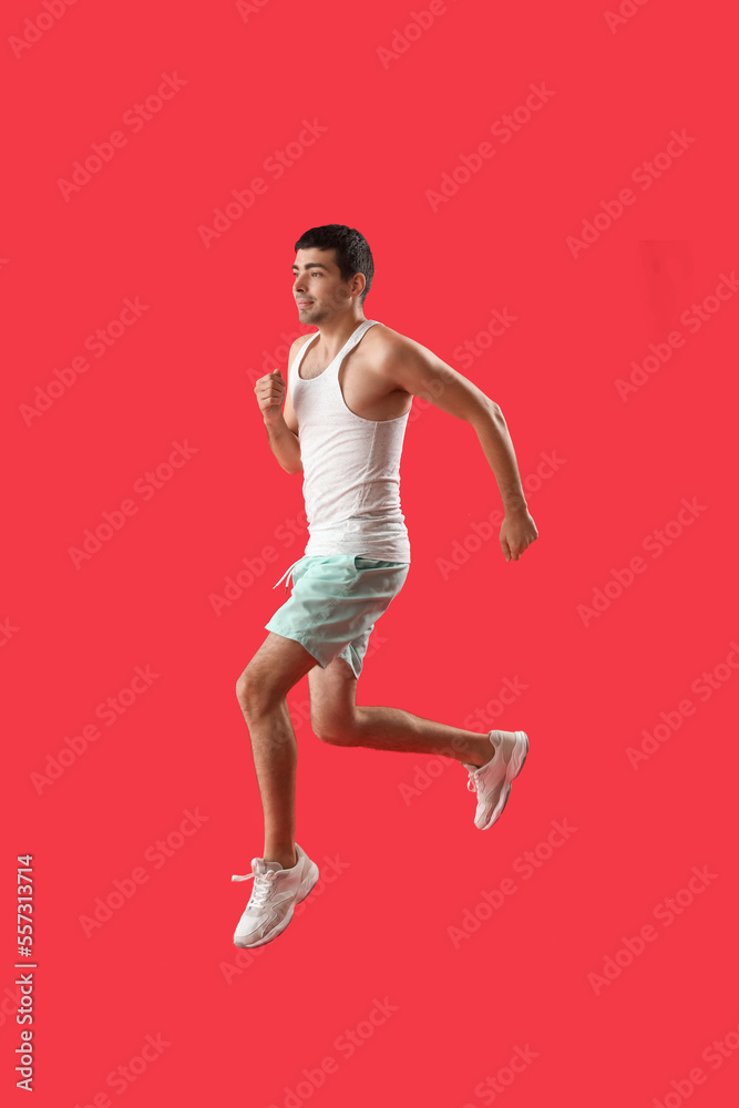 红色背景上跳跃的运动型年轻人