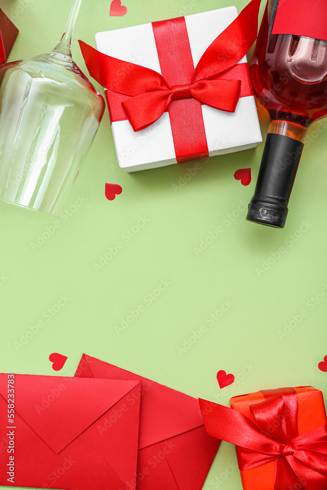 框架由礼物、酒瓶、玻璃和绿色背景的信封制成。情人节庆祝活动