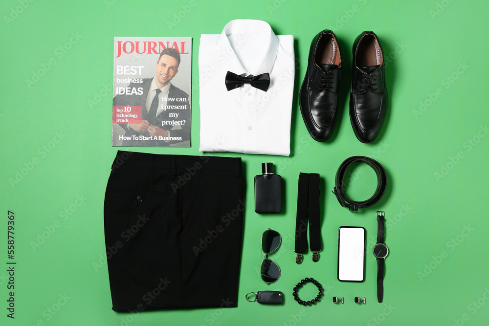 Male clothes, accessories and business magazine on green background