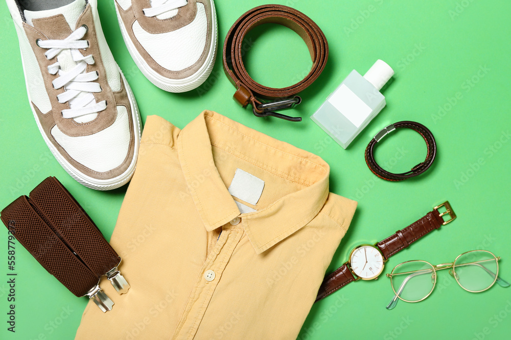 Male shirt, shoes and different accessories on green background