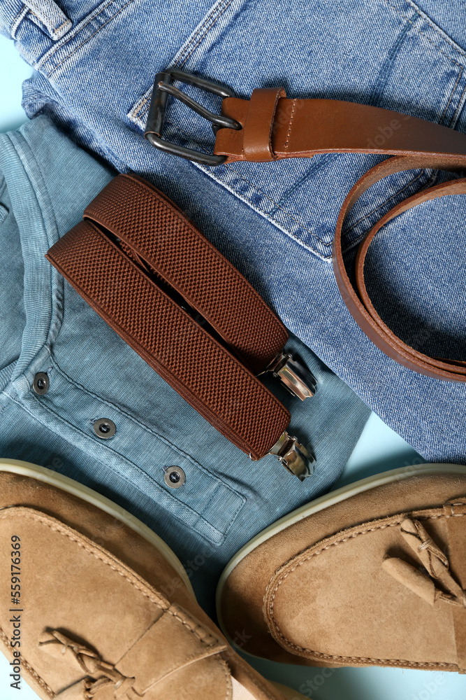 Male clothes, shoes and accessories on blue background, closeup