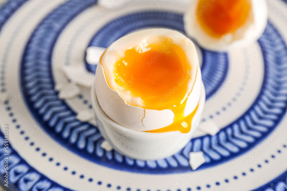 Holder with soft boiled egg on blue plate