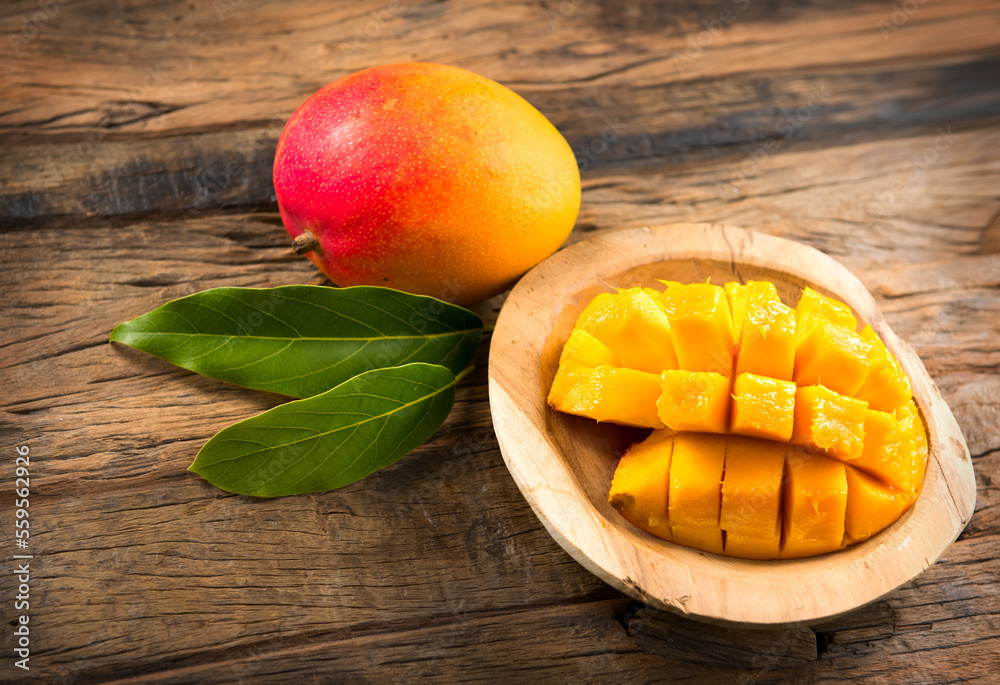 Mango fruit. Ripe Mango fruits over wood background. Close-up of fresh juicy tropical mango ready to