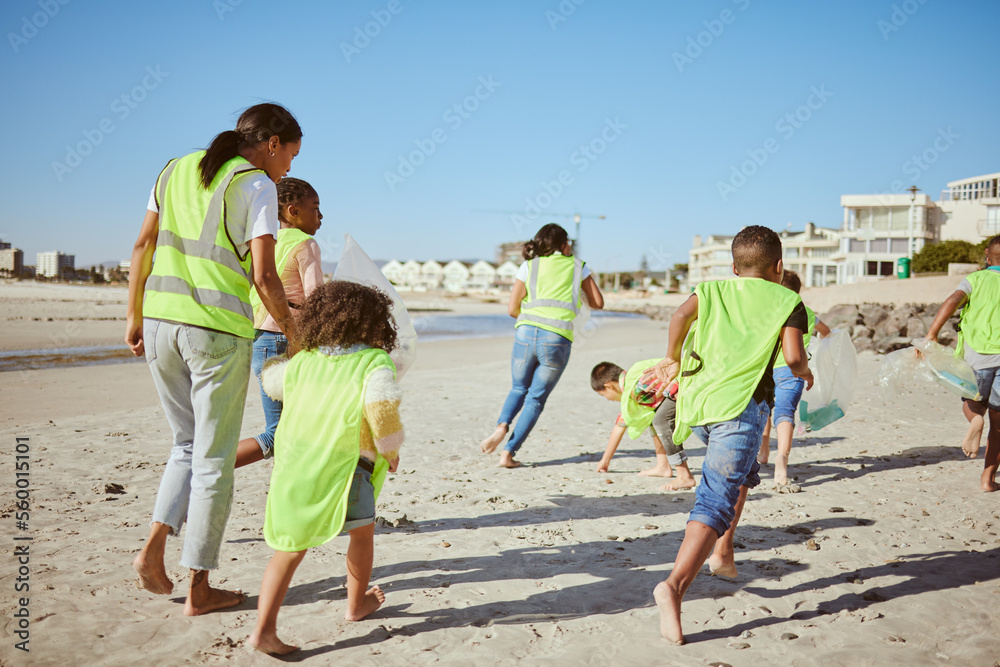 妇女和一群儿童为地球日的志愿服务、社区和慈善事业清洁海滩，c
