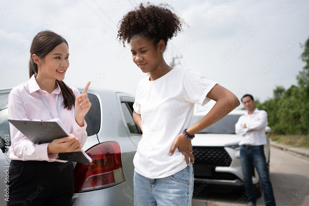 女司机与保险代理人交谈，检查损坏的汽车和客户对报告的检查cl