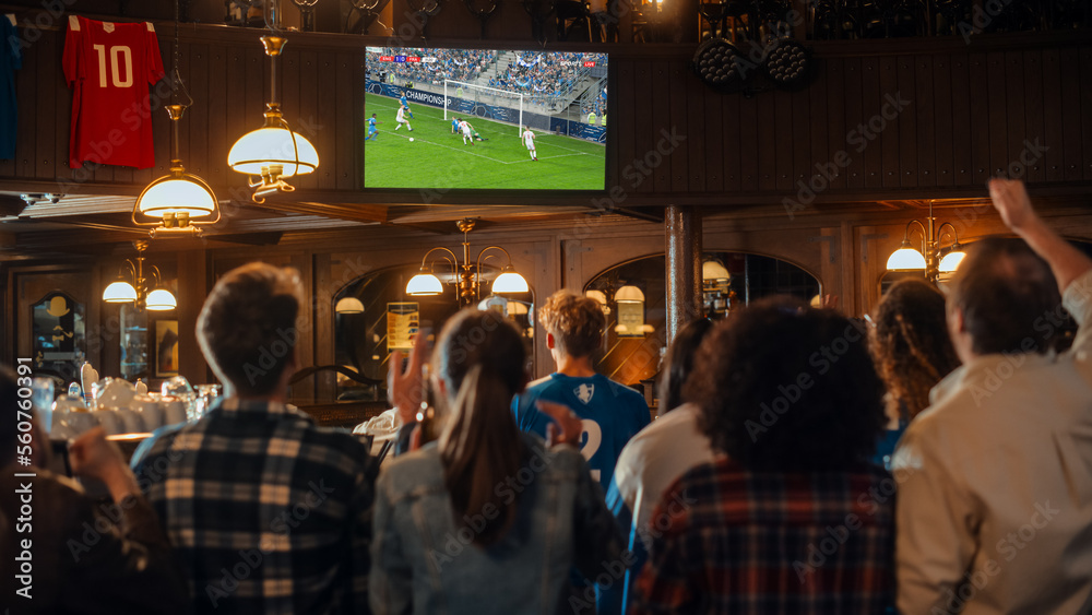 一群朋友在体育酒吧观看电视直播的足球比赛。激动的球迷欢呼呐喊