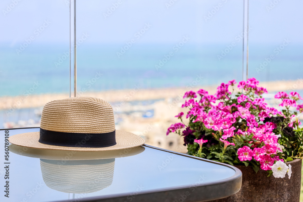 阳台上放着夏季帽子和鲜花的桌子，特写