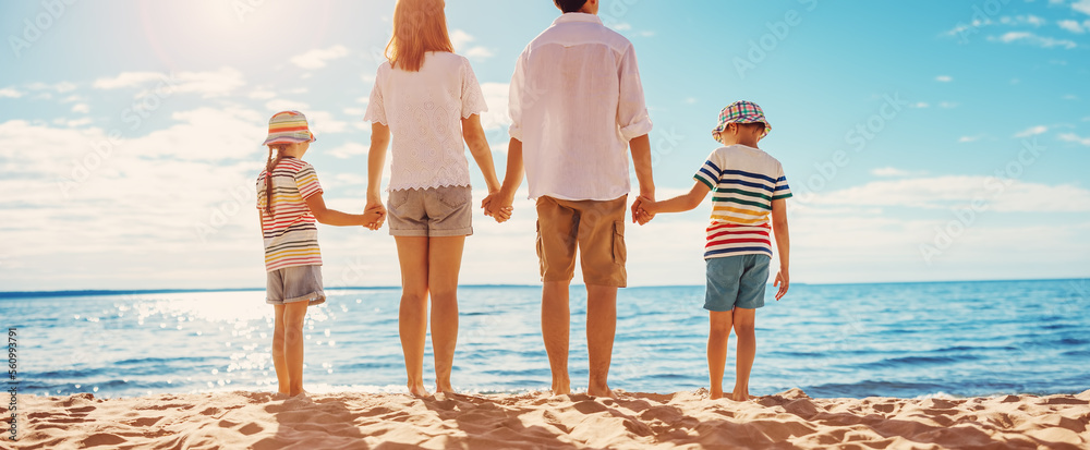 母亲和父亲带着孩子站在度假村的海滩上。