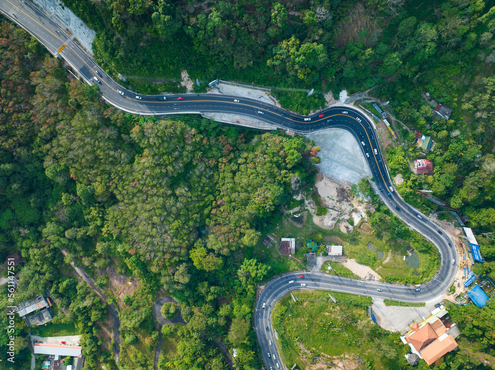 Aerial view top down drone shot above the winding mountain road between the trees rainforest,Phuket 