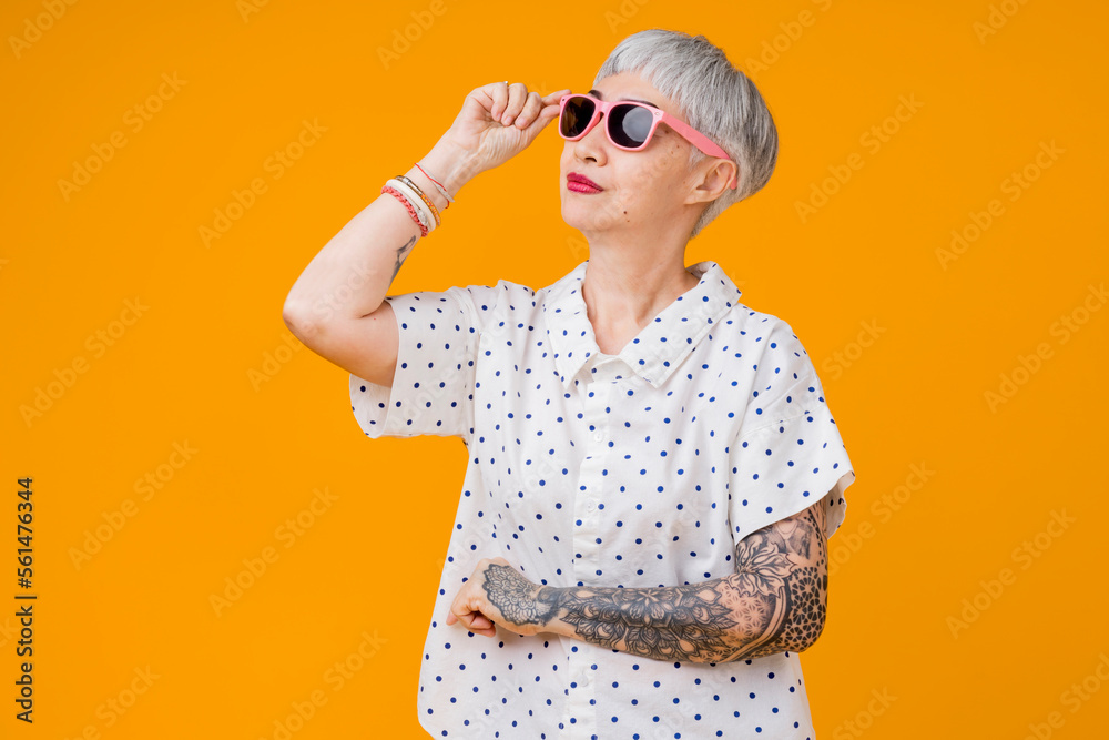 亚洲资深女性灰色头发造型布，带有纹身手臂，手势为正co