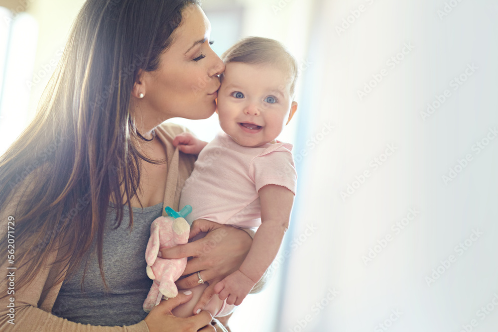 母亲，在家里的客厅、托儿所或家庭床上为女婴亲吻身体和额头