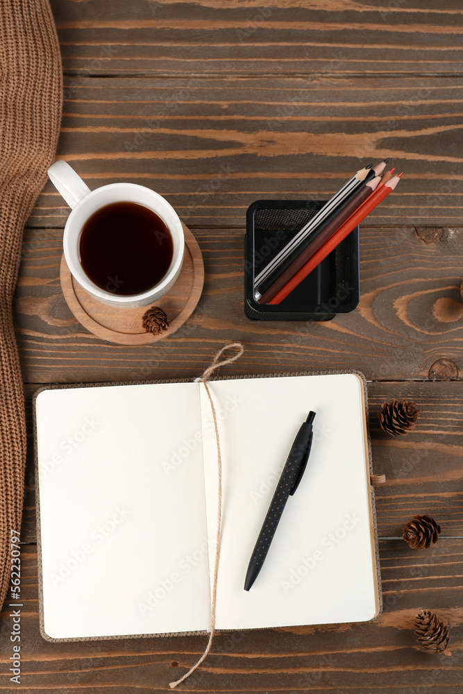 笔记本、文具架、一杯咖啡和木制松果