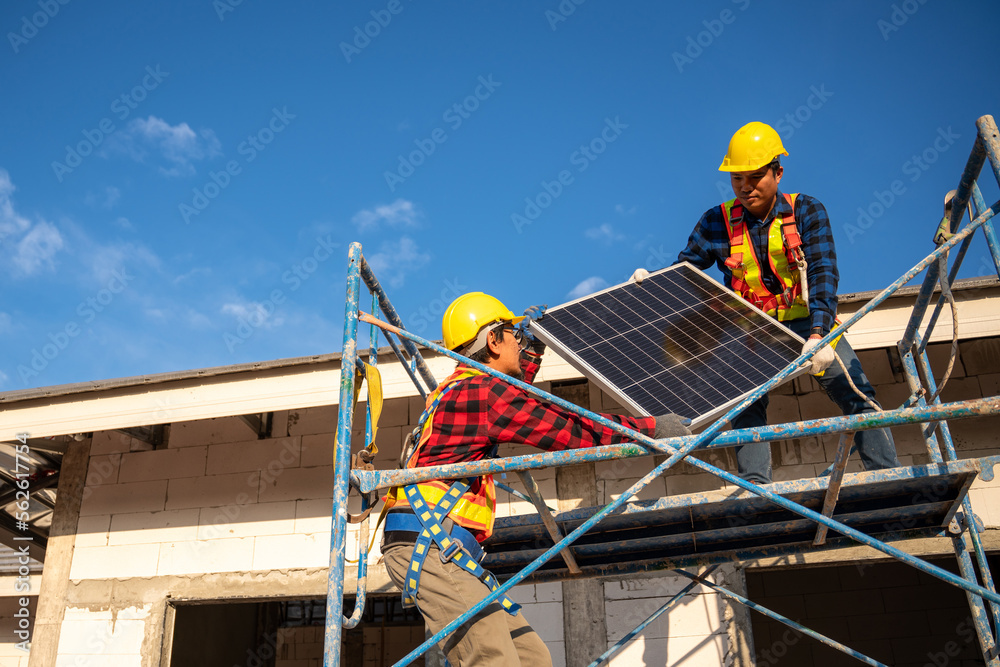 亚洲技术人员或穿着防坠落安全服的工人携带太阳能电池安装