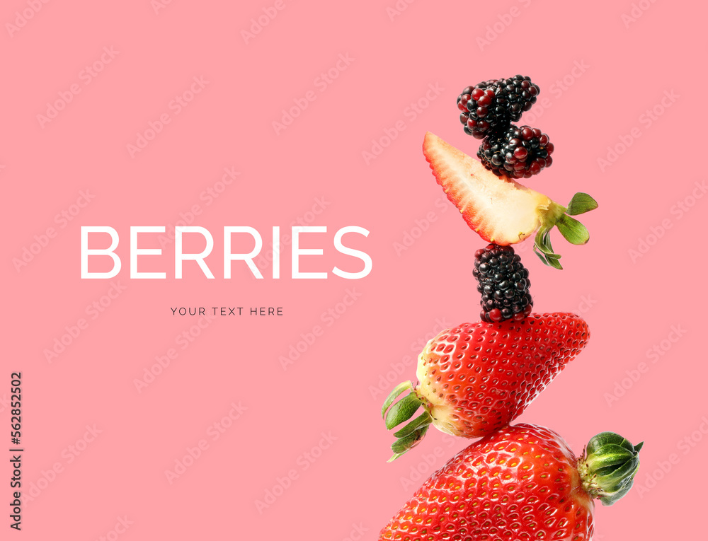 由草莓和黑莓在粉色背景上制成的创意布局。平躺。食物概念。
