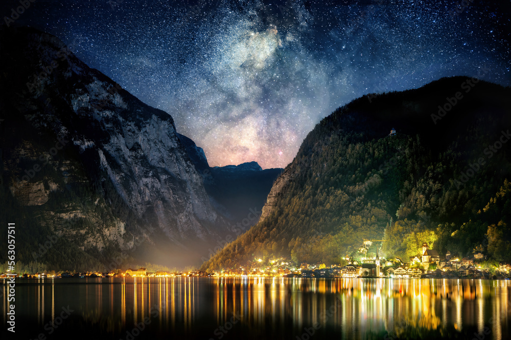Night sky with the Milky Way and mountains over the iconic town of Hallstatt in Austria, Europe