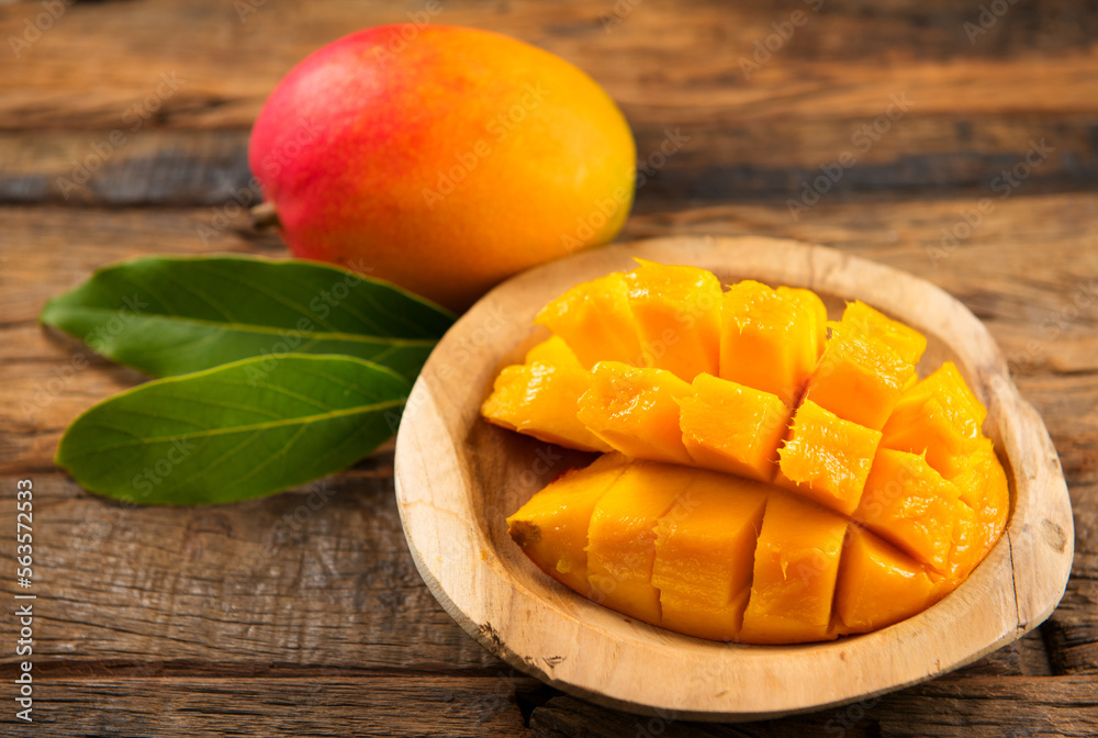 芒果果实。木质背景下成熟的芒果果实。新鲜多汁的热带芒果特写。