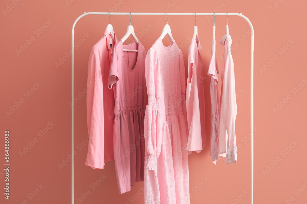 粉色墙壁附近的女性衣服架子