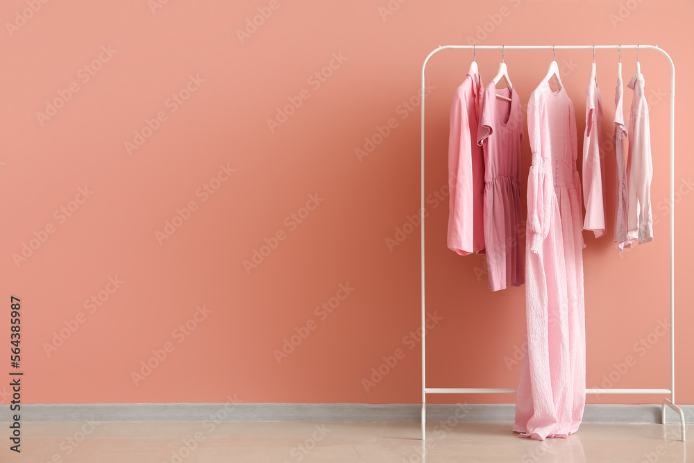 粉色墙壁附近的女性衣服架子