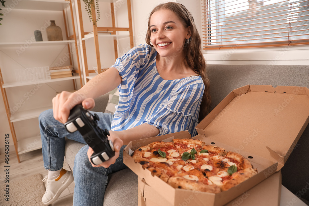 带着美味披萨的年轻女子在家玩电子游戏