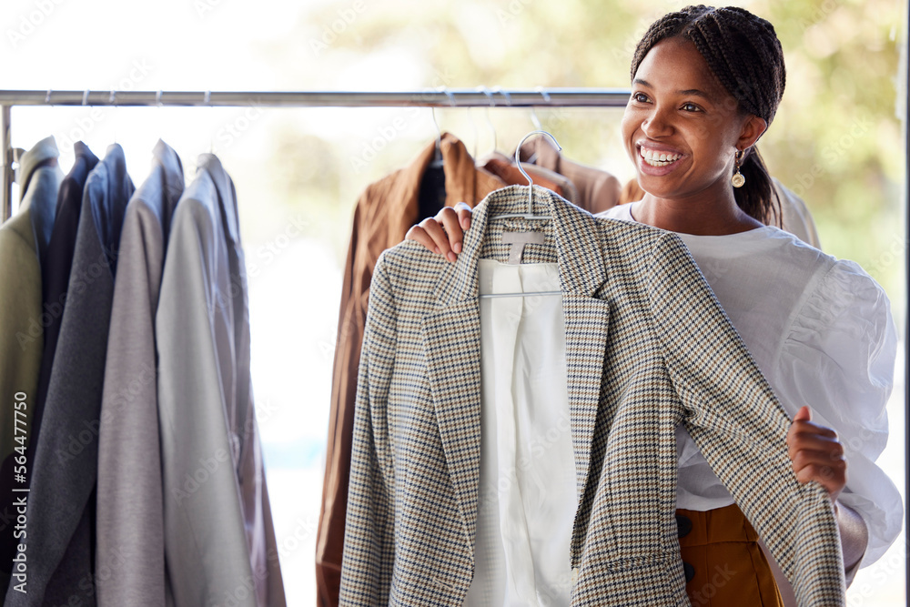 零售、购物和商店里的黑人女性，货架上有衣服可供选择，可供出售、折扣和促销
