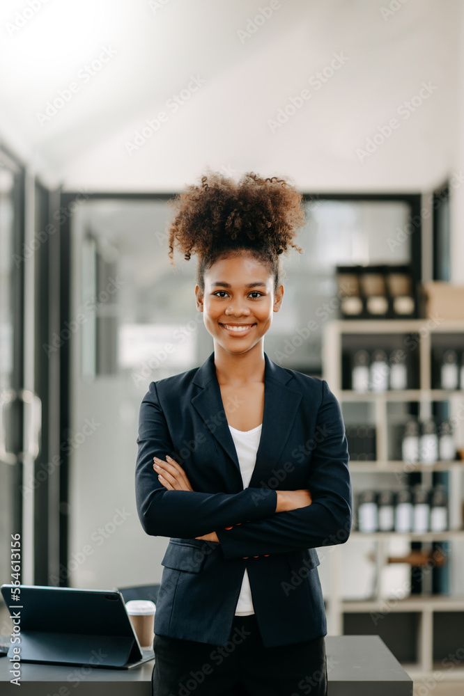 年轻迷人的非洲女上班族商务套装在办公室对着镜头微笑