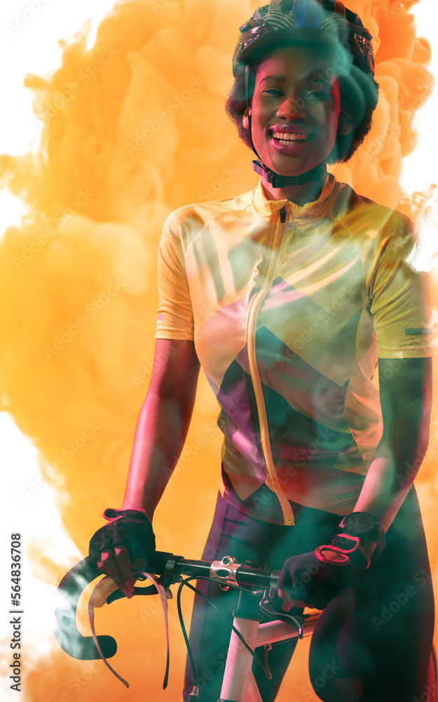 戴着头盔的非裔美国女运动员与自行车站在烟熏背景下的肖像