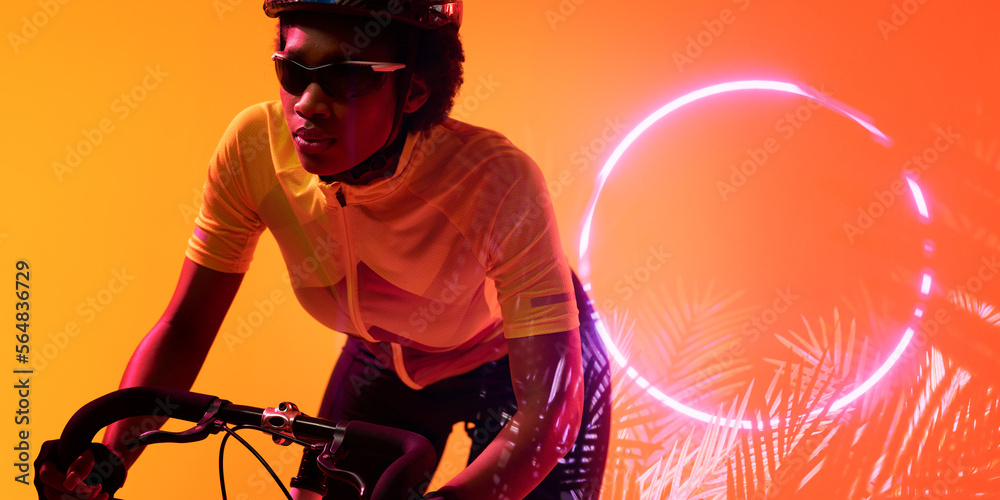 戴眼镜的非裔美国女运动员骑自行车经过发光的圆圈和植物，复制空间