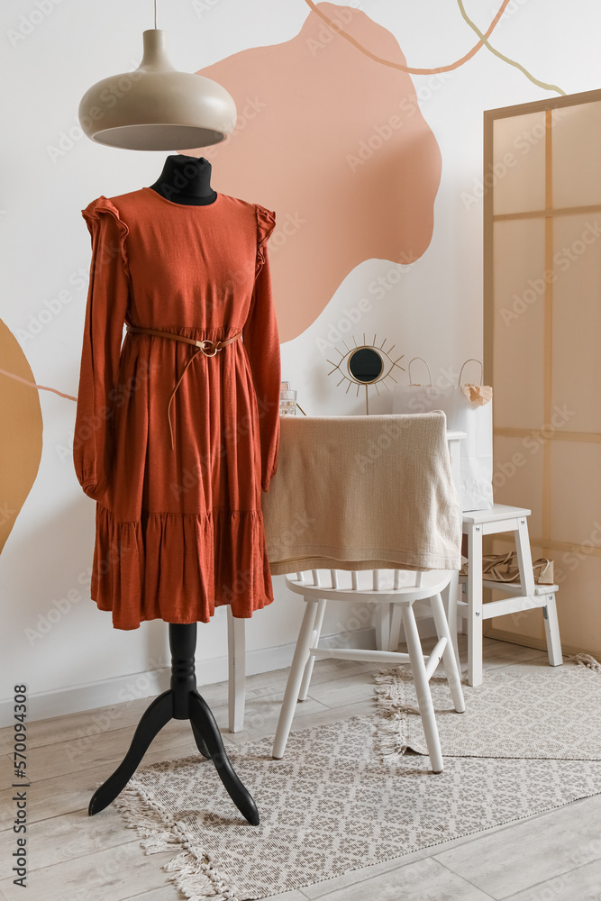 Interior of fashion designers studio with mannequin in red dress and workplace