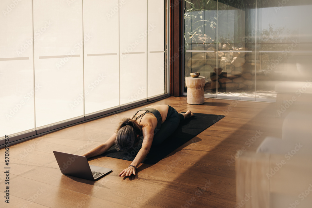 Woman doing a childs pose exercise during an online yoga class
