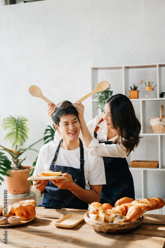 Image of newlywed couple cooking at home. Asia young couple cooking together with Bread and fruit in