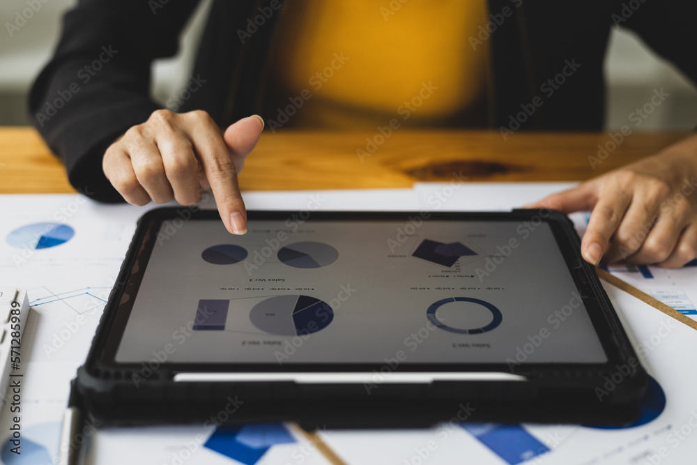 Businesswoman analyzing financial statistics displayed on the tablet screen, working data document g