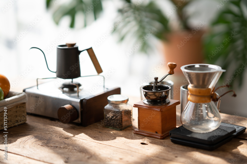 Coffee making concept, Old coffee grinder, manual hand mill on the table with coffee pot and coffee 
