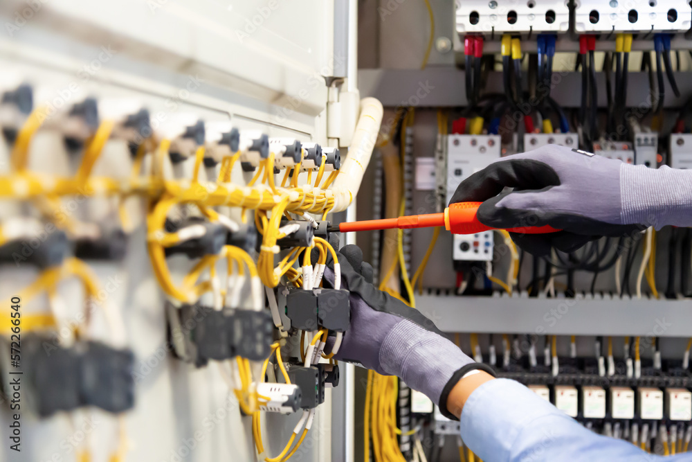 Electricians work to connect electric wires in the system, switchboard, electrical system in Control