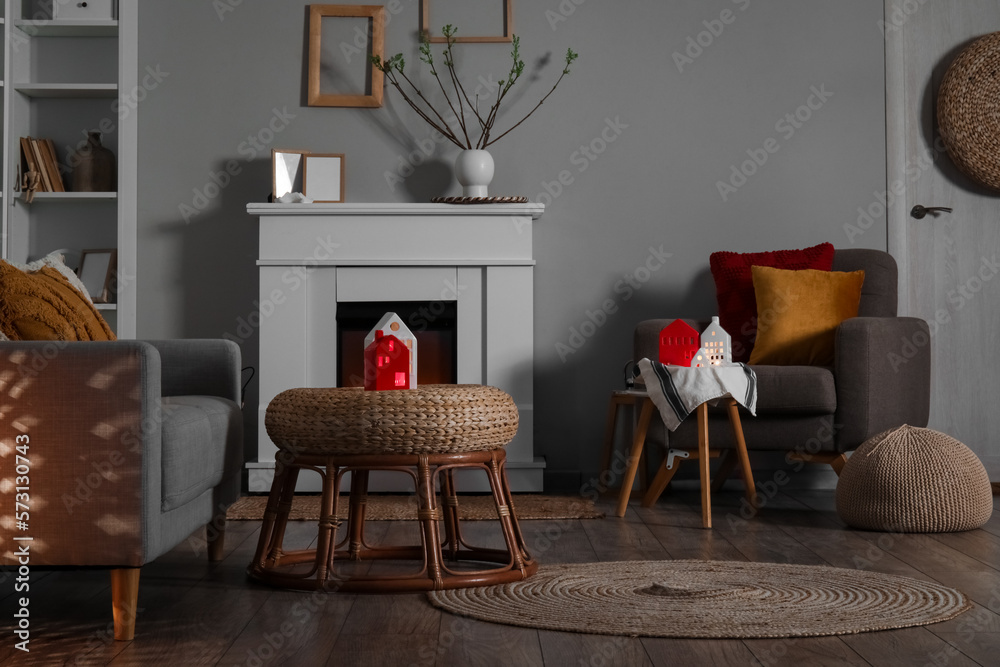 Interior of living room with fireplace, tables and house candle holders