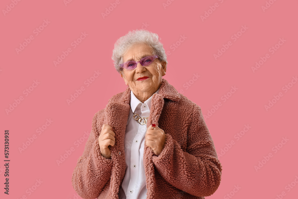 Senior woman in teddy coat on pink background