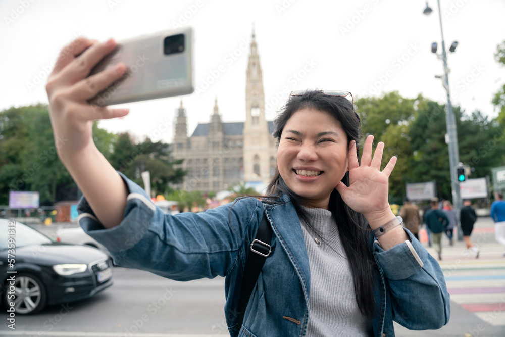 asian female woman  traveller enjoy holiday vacation city walking hand using smartphone taking photo