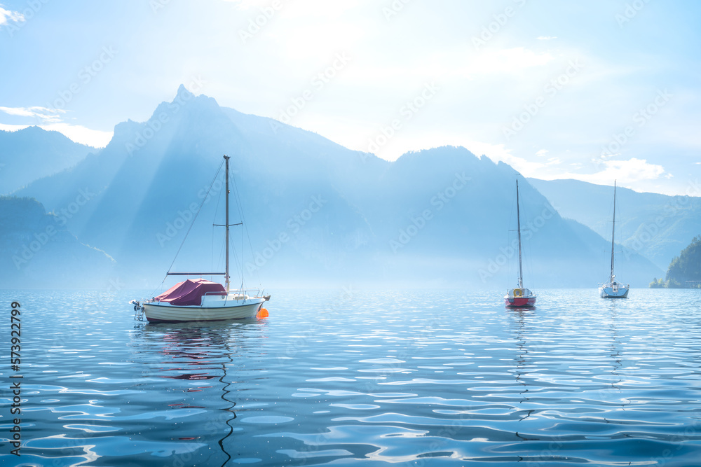 A yacht against the backdrop of the mountains in Switzerland. Calm water and bright sunny day. A pop